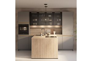 Moderne keuken met houten kookeiland, grijze kastenwand, zwarte kraan, ingebouwde oven en glazen bovenkasten met subtiele verlichting.