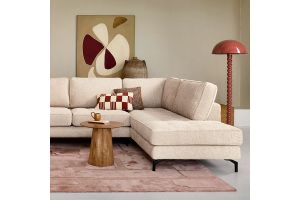 INHOUSE hoekbank in beige stof met chaise longue, gecombineerd met ronde houten salontafel en moderne rode vloerlamp in warme woonkamer