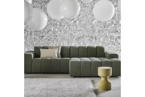 Groene modulaire bank in een modern interieur met witte hanglampen, zilveren textuurwand en zacht vloerkleed