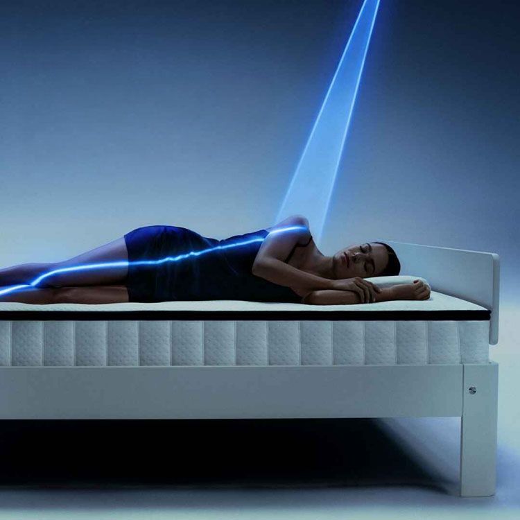 Auping matras met liggende persoon en lichtlijn die lichaamsondersteuning visualiseert.