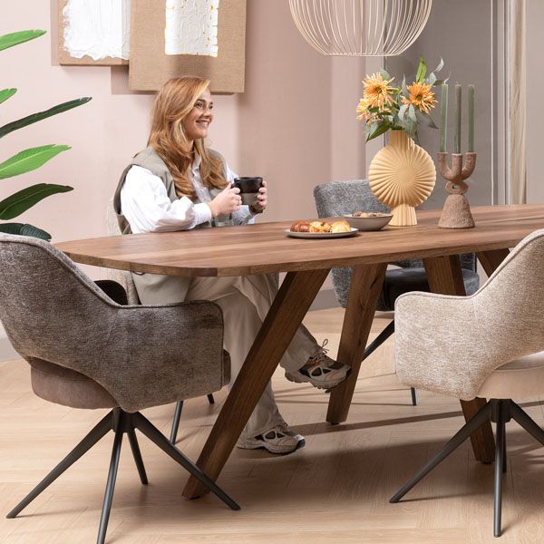 Gezellige eetkamer met houten eettafel, comfortabele draaibare eetkamerstoelen van Happy@Home en warme woonaccessoires in natuurlijke tinten