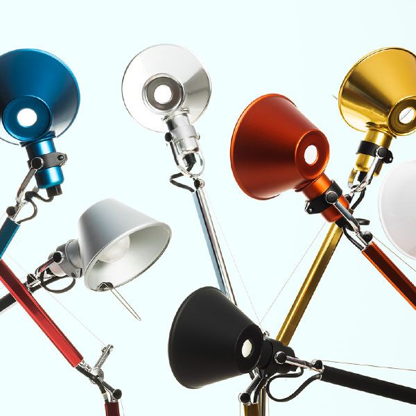 Kleurrijke design vloerlampen met verstelbare armen en metalen kappen in blauw, zilver, rood, goud, wit en zwart tegen een lichte achtergrond