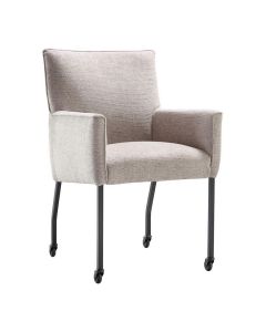 Eetkamerstoel Mianta van INHOUSE in beige stof, met armleuningen en zwart metalen poten op wieltjes, schuin van voren gefotografeerd.