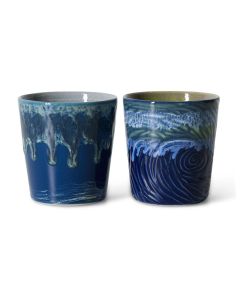 Twee keramieken koffiemokken in diepe blauwtinten met druipglazuur en golvend patroon naast elkaar