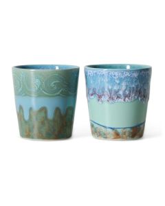 Twee keramische koffiemokken in blauwgroene tinten met golvende en druipende glazuurpatronen op witte achtergrond