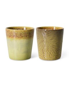 Twee keramische koffiemokken in geelgroene tinten met verschillend glazuur en patroon op witte achtergrond