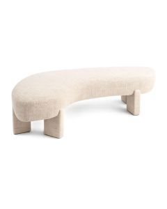 Beige bankje met golvende zitting en volledig gestoffeerde poten op lichte achtergrond