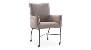 Moderne eetkamerstoel met een lichte stof op een zwart metalen frame met skatewieltjes. Gezien schuin van voren.