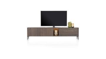 Lowboard TRENTON in claykleur, 240 cm breed, met latjesmotief, ledverlichte niche en metalen onderstel, gepresenteerd met een tv en decoratie.