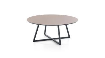 Salontafel Ginza van Baenks heeft een rond tafelblad van HPL en 4 zwart metalen poten die elkaar op de grond tegenkomen in een kruis.