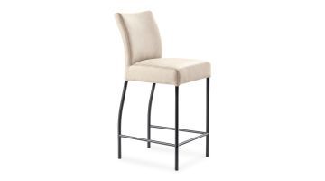 voorkant barkruk Sessione van pronto Wonen bekleed met beige microvezelstof. De kruk heeft een stoffen zitting en rugleuning en zwart metalen poten. De achterpoten zijn iets gebogen.