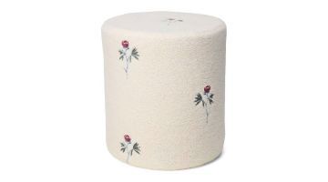 Teddy poef Marisol met geborduurde rode Maribel bloemen op een crèmekleurige teddy stof, close-up van de poef.