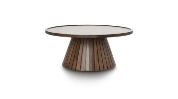 Een ronde salontafel Cleo van COCO Maison met een houten onderstel en een lichte tafelbladafwerking, geschikt voor moderne interieurs.