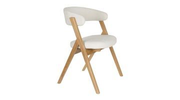 Eetkamerstoel Pom van Zuiver in een driekwart aanzicht, met een lichtbeige zitting en een houten frame.