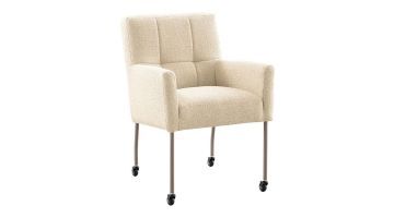 Eetkamerstoel Janinto van IN.HOUSE in beige stof, met zwarte wielen en slanke metalen poten. Schuine hoek vooraanzicht.