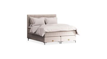 Luxe Mattsons Soulful bed met een elegant ontwerp in beige, compleet opgemaakt met hoogwaardige beddengoed en gouden details op de bedpoten.
