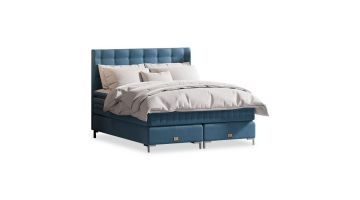 Luxe boxspring Elegance met blauw gestoffeerd hoofdbord en bijpassende matras, voorzien van elegante details en hoogwaardige afwerking.