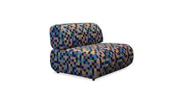 Schuin zijaanzicht van bankelement Juul in kleurrijke blokpatroon stof, met focus op het design.