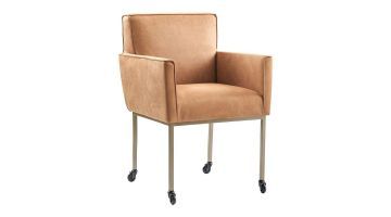 Eetkamerstoel Rona van INHOUSE in camel kleur, met armleuningen, metalen onderstel en wieltjes, zijaanzicht.
