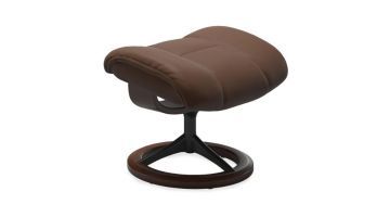 Stressless Ruby hocker in bruin leer met houten onderstel, zijaanzicht.