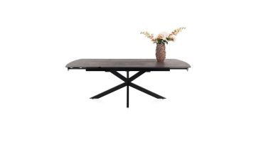 Vooraanzicht van de Henders & Hazel Pavalon uitschuifbare eettafel in roestkleur met zwarte spinpoot en bloemenvaas op het blad.