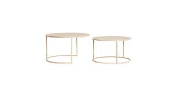 Twee ronde salontafels in zandkleurige afwerking, los van elkaar geplaatst voor een speels en luchtig effect in het interieur.