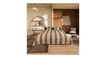 Dekbedovertrek Agui in taupe met kleurrijke strepen van Beddinghouse op een opgemaakt bed in sfeervolle, moderne slaapkamer.