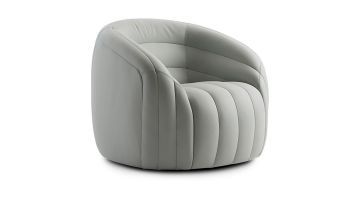   Een moderne fauteuil van Pode in lichtgrijs leer met ronde vormen en verticale stiksels, perfect voor een stijlvol interieur.