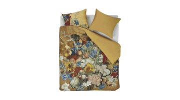 Dekbedovertrek Beddinghouse Bouquet d'Anniversaire met kleurrijk Van Gogh bloemenboeket op een goudkleurige achtergrond, opgemaakt op een bed.