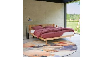 Auping Noa houten ledikant met opengewerkt hoofdbord en bordeauxrood dekbedovertrek in moderne slaapkamer