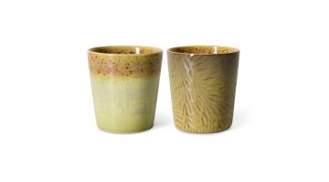 Twee keramische koffiemokken in geelgroene tinten met verschillend glazuur en patroon op witte achtergrond
