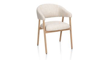 Armstoel Kira van XOOON in crème Luton-stof met armleuningen en massief eikenhouten onderstel in natural, schuin van voren gefotografeerd.