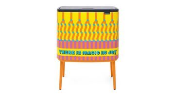 Brabantia Bo Touch Bin Yinka Ilori met geel, oranje, roze en blauw dessin op oranje poten.