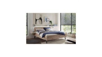 Wiemann ledikant Delft in moderne slaapkamer met groot raam, wit beddengoed en blauwe sprei.