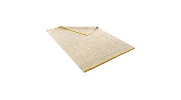 Karpet Rye van Pode handgemaakt van natuurlijke materialen. Getoond is de beige variant met goudkleurige uiteinden.