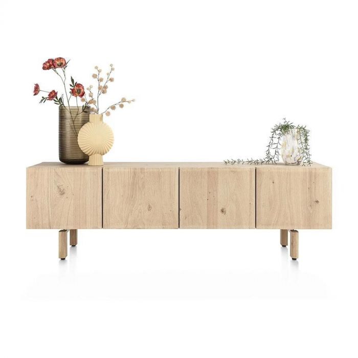 Vooraanzicht van het lowboard Azulo op houten pootjes, met vier gesloten deuren en decoratieve vazen bovenop.