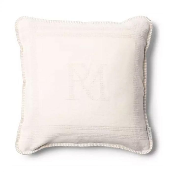 Kussenhoes Marino 50x50 cm van Rivièra Maison in offwhite met subtiel RM-logo en siersteekrand, bovenaanzicht op witte achtergrond.
