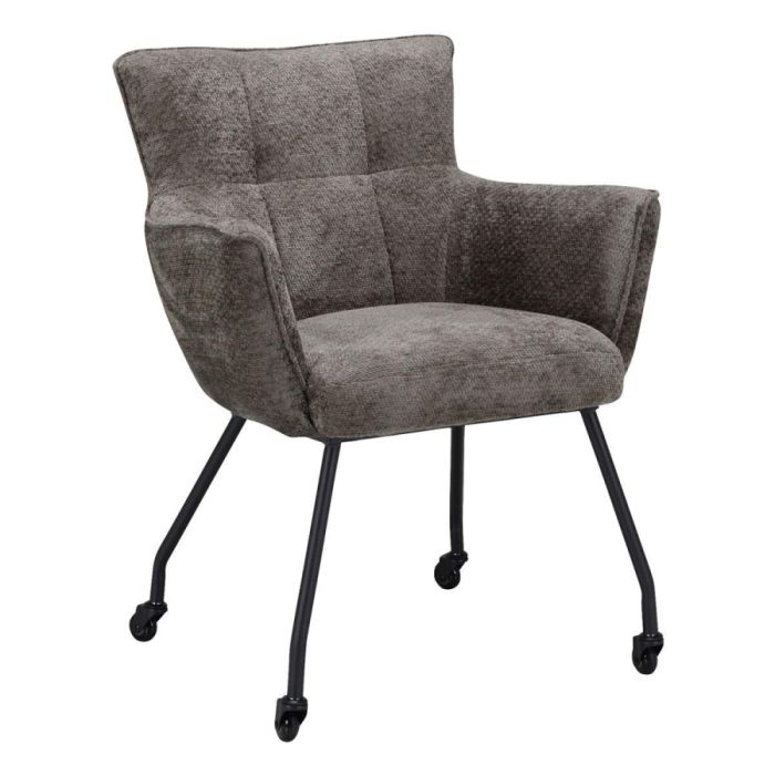 Pronto Wonen eetkamerstoel Novile Taupe met wieltjes, schuin van voren gefotografeerd, met taupekleurige zachte bekleding, armleuningen en zwarte poten op wielen tegen witte achtergrond.