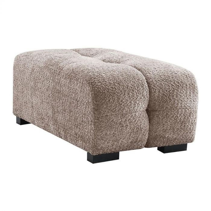 Close-up van de INHOUSE hocker Piastri in taupe teddy stof. De royale hocker heeft een zachte textuur, afgeronde hoeken en stevige zwarte pootjes.