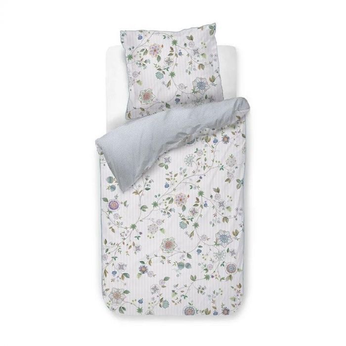 Dekbedovertrek Pip Studio Flores Bailando eenpersoons in wit met bloemenprint en blauwe achterzijde, opgemaakt op wit bed.