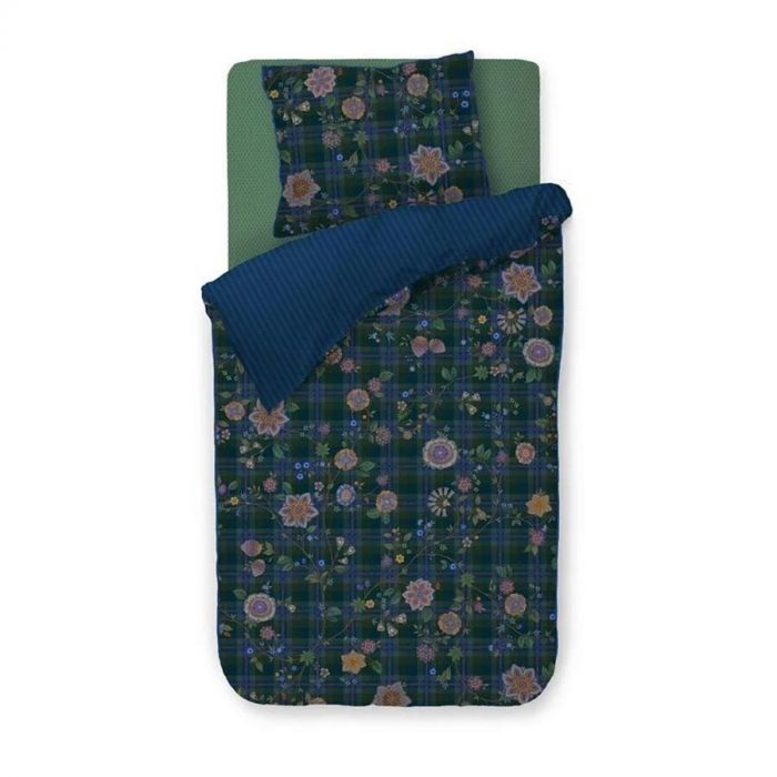 Pip Studio dekbedovertrek Flores Felices in donkergroen met bloemen en blauwe ruit, opgemaakt met kussens en contrasterende blauwe achterzijde.