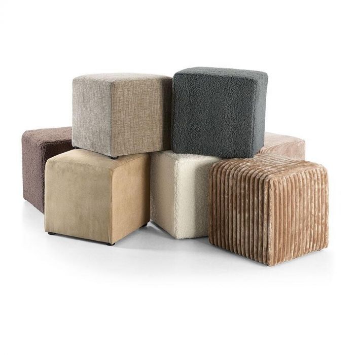 Verschillende INHOUSE poefjes Hebera in warme neutrale kleuren zoals beige, crème, bruin en grijs. De poefs zijn kubusvormig en hebben elk een andere stofstructuur, waaronder ribfluweel, bouclé en velours.