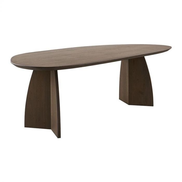 Eettafel Taranto in kiezel eikenhout schuin van voren gefotografeerd, met focus op het organische tafelblad en de brede houten poten.