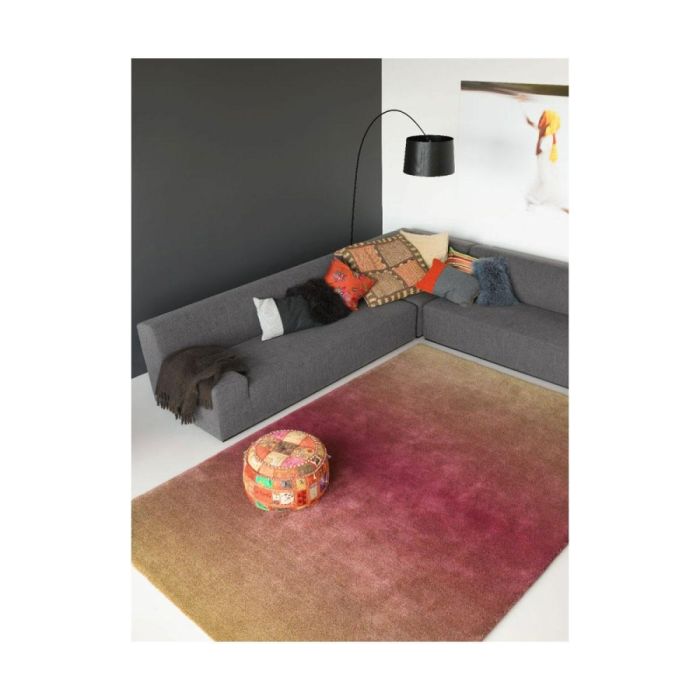 Caméléon vloerkleed met kleurverloop van roze naar bruin, gestyled in een moderne woonkamer met grijze hoekbank.