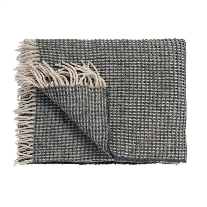 Vandyck Home 95 plaid in anthracite met wafelstructuur, wolblend en franjes, opgevouwen met hoekje omgeslagen op witte achtergrond.