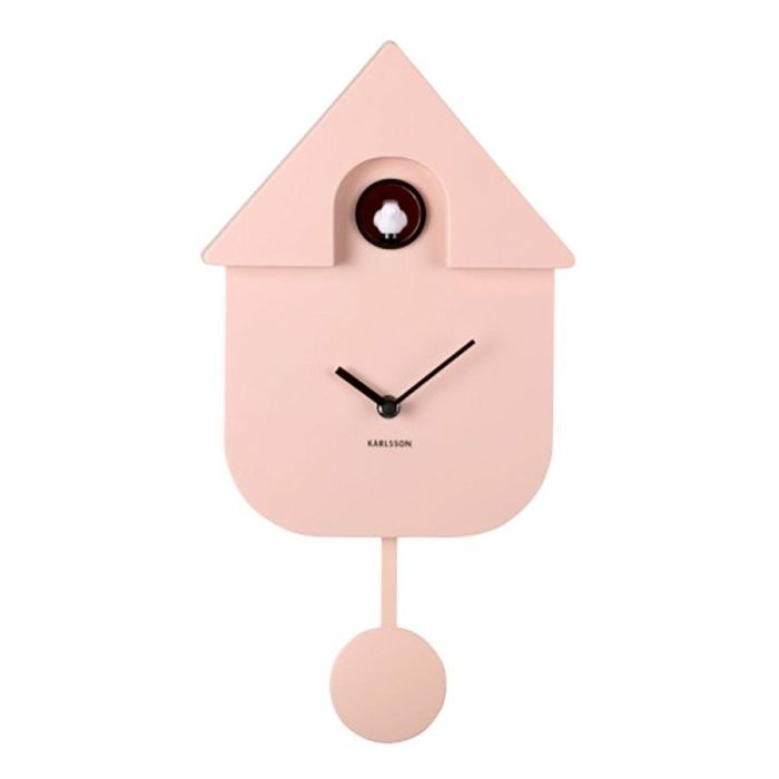 voorkant roze modern cuckoo klok van karlsson in het zachtroze. geen cijfers, alleen zwarte wijzers en een roze klepel met in het dak een rond holletje met daarin een wit vogeltje.