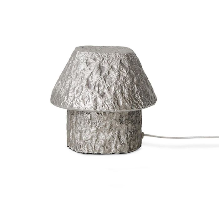 Aluminium tafellamp Artefact in paddenstoelvorm met ruwe, sculpturale structuur op witte achtergrond
