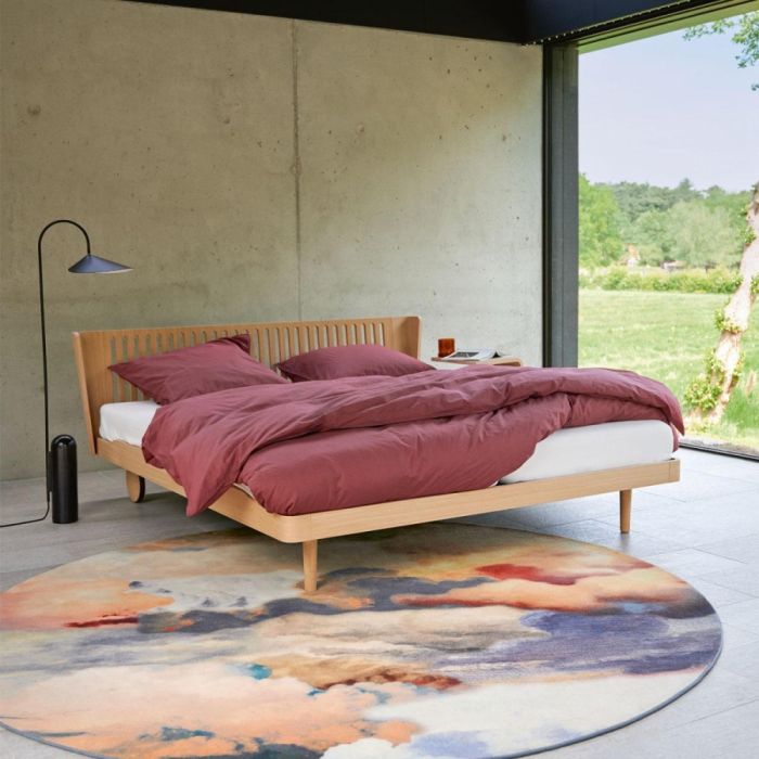 Auping Noa houten ledikant met opengewerkt hoofdbord en bordeauxrood dekbedovertrek in moderne slaapkamer