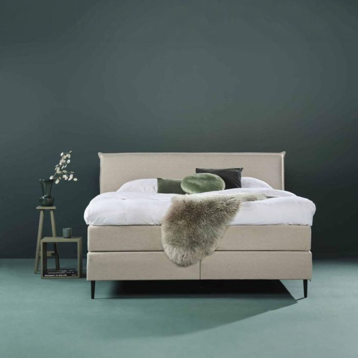 Beige Eastborn GO boxspring in sfeervolle slaapkamer met groene accenten en zachte plaid