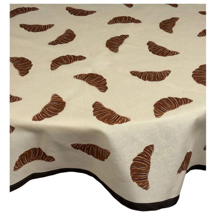 Beige tafelkleed met bruine croissantprint over tafel met donkere rand langs de onderzijde